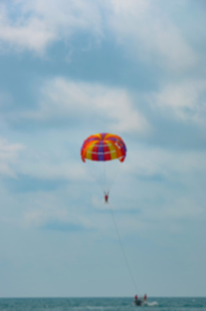 paragliding in the cloudy sky above the seaの写真素材