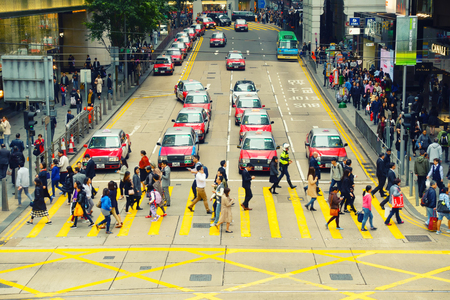 Hong Kong - February 23, 2017: Business downtown of Hong Kong and crowded people accross the street.のeditorial素材