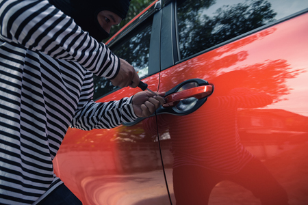 Car thief trying to unlock a car by screwdriver.の写真素材