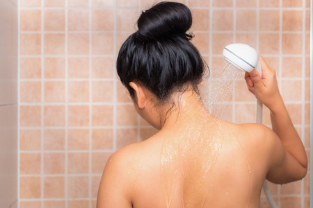 Portrait of beautiful woman taking shower in bathroom.の写真素材