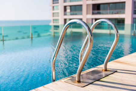 Grab bars ladder in swimming pool on the deck floor.