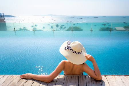 Portait of asian woman relaxing in swimming pool with sunbathe.の写真素材