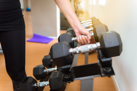 Portrait of asian woman lifting dumbbells in fitness gym., Sport club and fitness gym concept.の写真素材