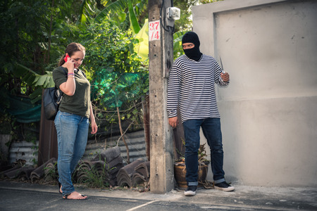 Street robbery waiting and trying to taking a bag from female victim.の写真素材