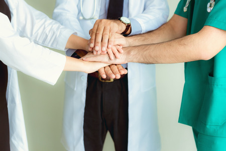 Close up portrait of doctors teamwork stacking hands together at hospital.の写真素材