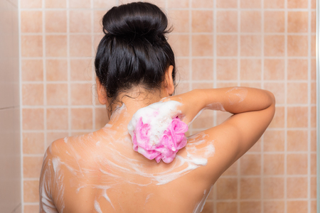 Portrait of beautiful woman taking shower with bath sponge., Shower conceptの写真素材