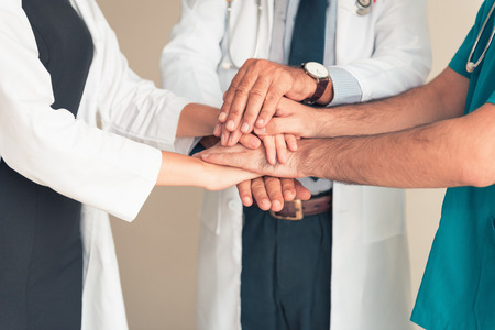 Portrait of doctor team joining hands stacking and handshake together., Unity and teamwork concept.の写真素材