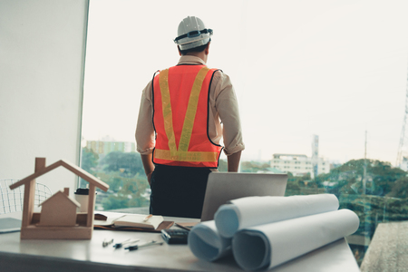 Portrait of construction engineer is looking at site construction through the glass of windows.の写真素材