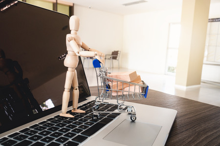 Mini cart and wooden model on keyboard laptop, Shopping online concept.の写真素材