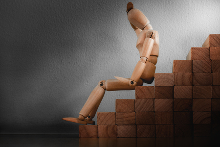 Sadness concept, Wooden model is expression sadness emotion while sitting on staircase.の写真素材