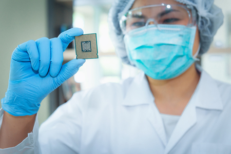 Portrait of computer engineer is holding CPU's computer for examination.