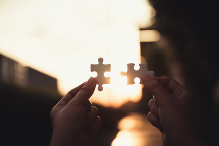 Closeup of woman hands connecting jigsaw puzzle on sunset scene, Business solutions, success mission...