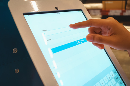 Closeup of woman hand pressing username and password on computer screen monitor to accessing for searching something in department store.の写真素材