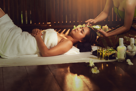 Thai girls therapist body spa massage and lying relaxation in business massaging and salon shop., Pretty attractive asian woman is relaxing by beauty skin care after traveling in Thailand.の写真素材