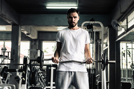 Handsome man is rowing exercise with bodybuilder equipment in fitness club.,Portrait of strong man doing working out calories burning in gym., Healthy and fitness sport gym concept.の写真素材
