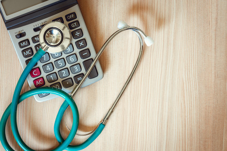 Stethoscope on calculator of health checkup insurance statement concept., Medical equipment for business healthcare and medicine on table., Occupation doctor.の写真素材