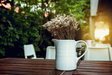 Home and outdoor gardening decoration with bouquet in a ceramic vase layout on wooden table desk., House or restaurant shop of resting area design.の写真素材