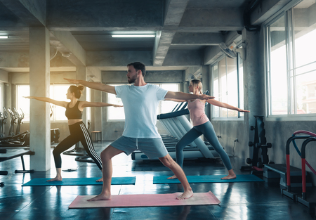 Group of young sporty yogi practicing yoga with instructor in gym., Sporty people in sportswear are working out training yoga in fitness club., Healthcare and leisure activities concept.の写真素材