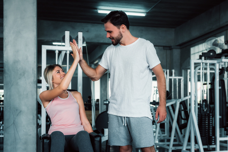 Attractive fitness couple love giving high five together after workout in fitness gym., Portrait of man and woman sporty are working out training together., Couple fitness and healthy concept.の写真素材