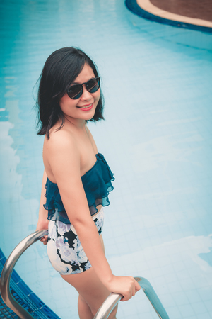 Portrait of Beautiful Woman Relaxing in Swimming Pool, Recreation Sport Outdoor and Summer Vacation., Pretty Woman in Swimsuit With Relaxing Sunbathing Beside Poolside. Summer Holiday Conceptの写真素材