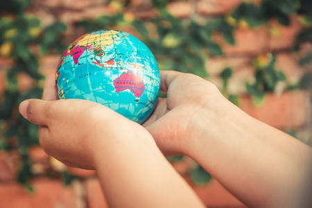 Save The Earth Concept, Woman Hands is Holding Mockup The Global on Tree Leaves Background. Creative Idea for Conservation Environmental and Planet.の写真素材
