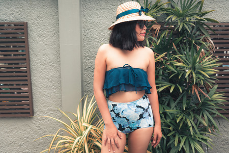 Portrait of Beautiful Woman Relaxing in Swimming Pool, Recreation Sport Outdoor and Summer Vacation., Pretty Woman in Swimsuit With Her Hat Relaxing Sunbathing Beside Poolside. Summer Holiday Concept.の写真素材