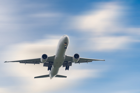 An Airplane is Flying in The Clouds Sky on Vacation Journey, International Aviation and Passengers Transportation, Holiday Trip and Traveling Tourist Concept.の写真素材