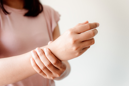 Close-Up of Woman Hand is Massaging Her Wrist Pain From Homework. Muscle Illness and Office Syndrome Concept. Healthcare and Medicineの写真素材