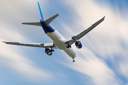 An Airplane is Flying in The Clouds Sky on Vacation Journey, International Aviation and Passengers Transportation, Holiday Trip and Traveling Tourist Concept.の写真素材