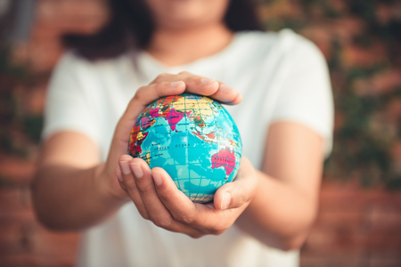 Save The Earth and Care Environment Concept, Close-up Portrait of Woman is Holding Mockup Global in Her Hands on Tree Leave Background. Save The Planetの写真素材