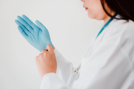 Close-Up of Female Doctor is Wearing Glove With a Stethoscope on White Isolated Background. Surgeon Occupation, Healthcare and Medicine concept.の写真素材