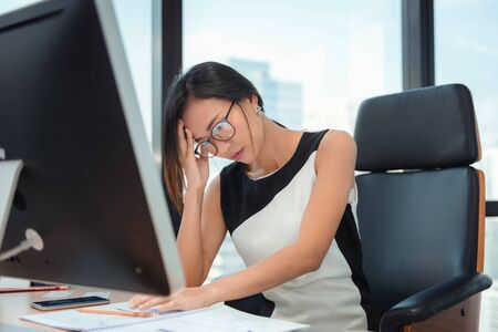 Portrait of Businesswoman Having Exhausted Tired and Headache While Working in Her Office. Business Financial and Healthcare Concept.の写真素材
