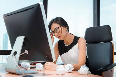 Business Woman Having Exhausted Tired and Headache While Working in Her Office. Businesswoman Having Head Ache Expressions after Overworks, Business Financial and Healthcare Concept.の写真素材