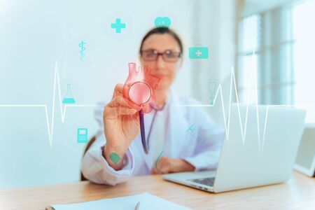 Female Medical Doctor is Holding Stethoscope for Heart Model Check Up in Laboratory, Scientist Practitioner is Analyzing Health Problem With Technology 3D Heart Model., Healthcare/Medicine Occupationの写真素材