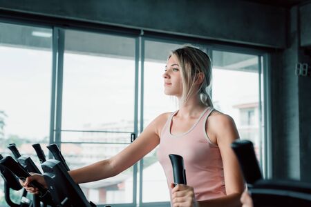Sporty Woman Exercising Workout on Elliptical in Fitness Training Club., Pretty of Caucasian Women in Sportswear Working Out Cardio Training at Gym.,Wellness Exercise Program and Sport Healthy Conceptの写真素材