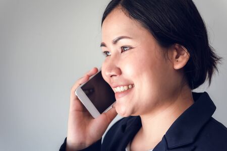 Close-Up Portrait of Businesswoman is Calling on Mobile Phone, Attractive of Asian Woman is Talking on Her Smartphone and Smiling While Communicating., Technology Communication and Business Financial.の写真素材