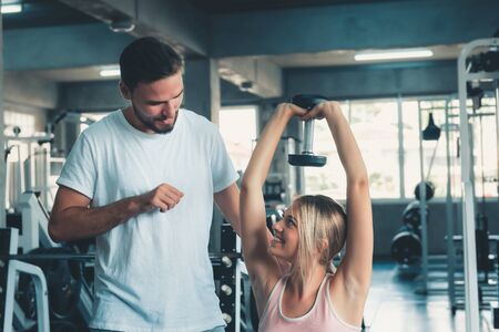 Sporty Couple Love in Fitness Exercised Training With Dumbbell Equipment., Young Couple Caucasian are Working Out and Training Together in Gym Club., Sport Exercising and Healthy Concept.の写真素材