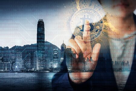 Double Exposure Business Finance and Technology Cryptocurrency Concept, Business Woman Hand is Pressing Bitcoin With Hong Kong Cityscape and Digital Code Background. Business Financial/Crypto Currencyの写真素材