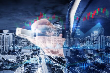 Business Stock Investment and Technology Telecommunication Communication Network Connection Concept, Double Exposure of City and Business Woman Using Mobile Phone for Communicating Trade Investing.の写真素材
