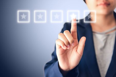 Business Entrepreneurs Woman is Choosing Quality Performance Certification and Satisfaction Stars Rating Feedback for Improvement on Multimedia Touch Screen., Poll Rate of Qualification and Satisfied.の写真素材