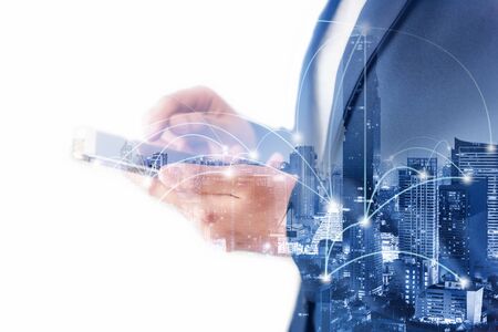 Business Technology Telecommunication and Communication 5G Network Connection Concept, Double Exposure of Businesswoman Using Mobile Phone With Graphic Media Screen and Cityscape Skyscrapers.の写真素材