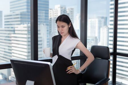 Portrait of Businesswoman is Working on Her Table Desktop in Office Workplace, Attractive Beautiful Business Woman is Concentrate on Her Work While Drinking Coffee., Occupation and Career Conceptの写真素材