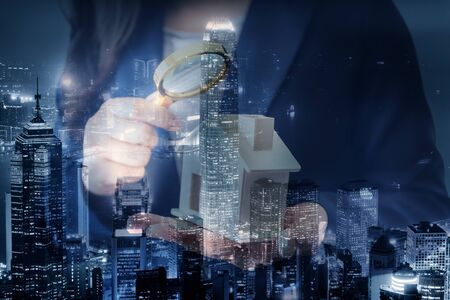Business Real Estate and Residential Investment Concept, Broker Sell Agency of Property Estates Investigation By Magnifying Glass for Searching New Housing on Cityscape Background. Double Exposureの写真素材