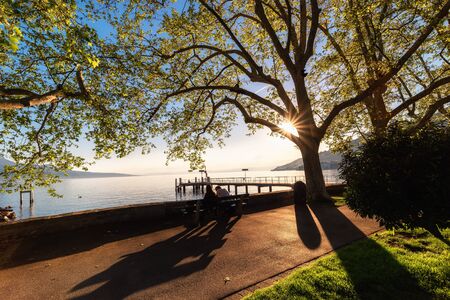 Natural Landscape Scenery View of Lake Geneva and Swiss Alps at Switzerland, Nature Scenic Horizontal Waterfront of Lake at Sunset. Panoramic Lakeside of Geneva in Spring Season at Vevey, Switzerland.の写真素材