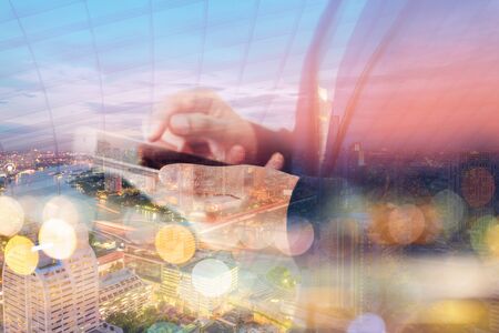 Business Technology Telecommunication and Communication 5G Network Connection Concept, Double Exposure of Businesswoman Using Mobile Phone With Graphic Media Screen and Cityscape Skyscrapers.の写真素材
