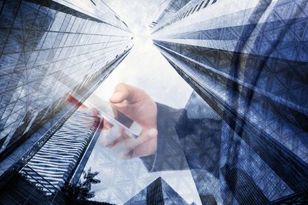 Business Technology Telecommunication and Communication 5G Network Connection Concept, Double Exposure of Businesswoman Using Mobile Phone With Graphic Media Screen and Cityscape Skyscrapers.の写真素材