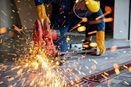 Craftsman Welding is Cutting Steel Work, Welder Man in Safety Protective Equipment Doing Metalwork in Construction Site. Engineering Labor Skill and Workshop Production Conceptの写真素材