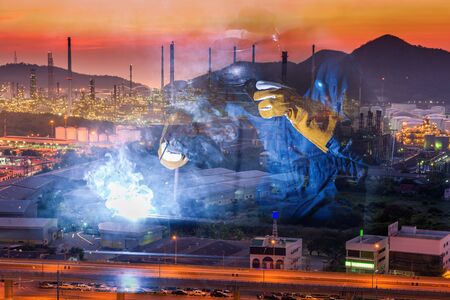 Double Exposure of Welder is Welding Pipeline Fabrication Assembly on Oil and Gas Refinery Manufacturing Plant Background. Technician Welding in Safety Protective Equipment is Working Metalwork.の写真素材