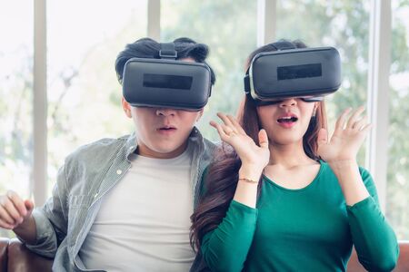 Young Couple Having Fun While Watching Video Via Virtual Reality Together. Couple Love Having...