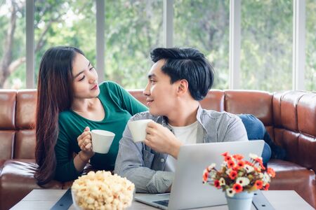 Couple Love Having Relaxation Discussing While Drinking a Coffee in Their Home, Attractive Asian Couple Happiness in Romantic Moments at Living Room. Relaxing and Lifestyles Conceptの写真素材